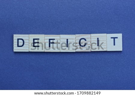 the text of the gray word deficit of small wooden letters on a black background