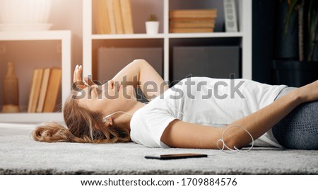 Half-body pic of tired sportswoman lying on floor at home after hard training, low angle