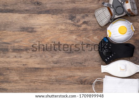 Different protective masks on wooden background, top view with copy space Royalty-Free Stock Photo #1709899948