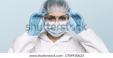 Female Doctor or Nurse Wearing latex protective gloves and medical Protective Mask and glasses on face. Protection for Coronavirus COVID-19 Royalty-Free Stock Photo #1709930623