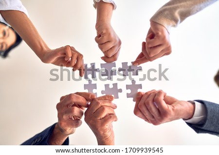 Group of business workers with hands together connecting pieces of puzzle at the office Royalty-Free Stock Photo #1709939545