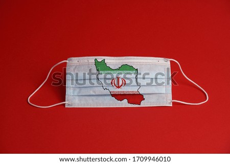 Coronavirus protective mask. Medical mask with Iran flag and map. Red background. Face mask protection against pollution, virus, flu. Healthcare and surgery concept.
