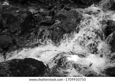 Black and white retro photo of fast mountain stream