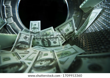 Washing banknotes in machine, money laundering, financial fraud concept Royalty-Free Stock Photo #1709953360