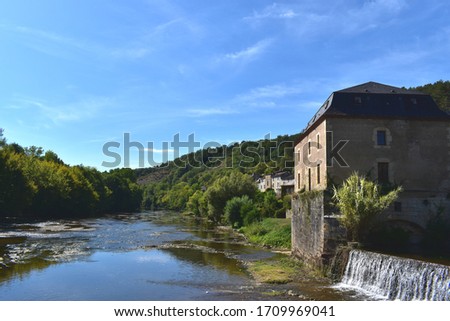 Picture of a beautiful river lined with stone houses in south of France. Countryside vacation background.