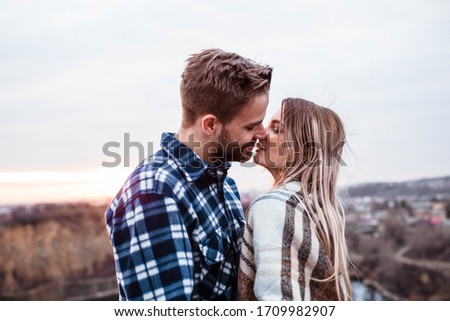 Young couple kissing at sunset. Man and woman. Man in shirt . Camping.