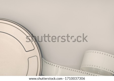 Motion Picture Film Can and film strip on table. Movie or TV background. Top view, Copy space