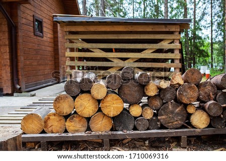Wooden bath in the cottage village. Woodpile. Structures in the forest.