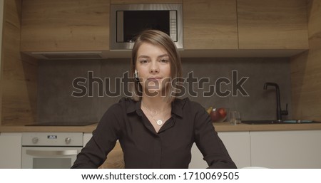 Smiling young caucasian woman blogger vlogger influencer sit at home kitchen speaking looking at camera talking make video chat, conference call record lifestyle blog vlog, webcam view Royalty-Free Stock Photo #1710069505