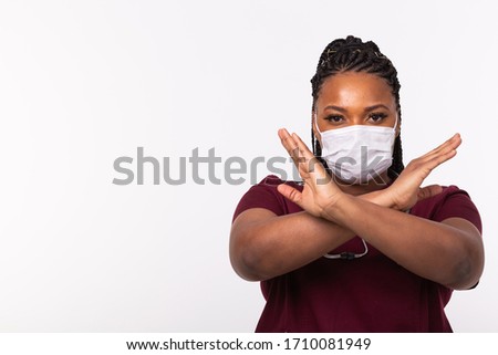 Doctor crossed hands on chest on white background with copy space. He is wearing medical mask. No or stop gesture. Coronavirus, covid-19 and pandemic concept.