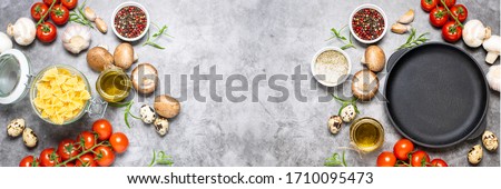 Assortment of fresh organic ingredients for cooking pasta and black empty pan on dark stone background. Healthy food concept. Long banner format. Culinary blog template. Royalty-Free Stock Photo #1710095473