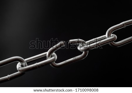 The team is as strong as its weakest link and single point of failure concept with powerful iron chain with one stressed link breaking under physical pressure isolated on black background Royalty-Free Stock Photo #1710098008