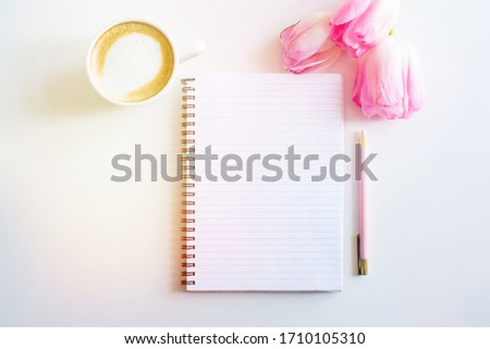 Empty notebook spring pink tulips flowers, cup of coffee. Mockup notepad on white background. Still life. Spring romantic mood. Colorful light. Top view. Copy space