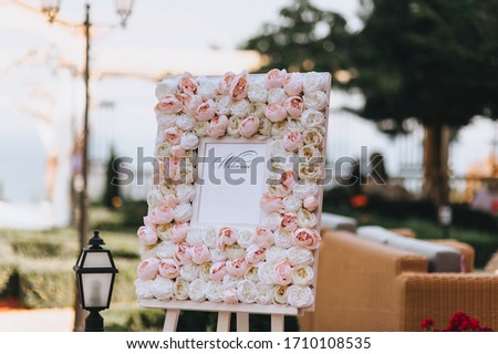 Wedding, festive stand, decorated with fresh roses, with invitational words welcome stands at the ceremony against the backdrop of nature. Photography, concept, copy space.
