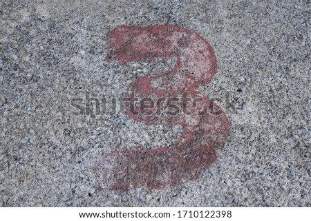 red number three on old concrete floor. no.3 spraying paint on the ground