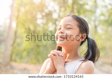 cute little girl hands praying to god with the bible in the morning on nature background.  little asian girl hand praying for thank god. copy space. spirituality and religion faith hope concept. Royalty-Free Stock Photo #1710124165