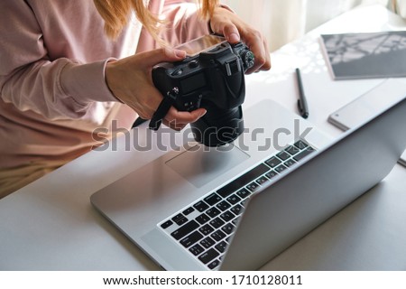 Woman working on laptop in home. Freelance photographer edit photos on computer. Professional photography business. Girl workspace with computer and photo camera. Creative artist lifestyle