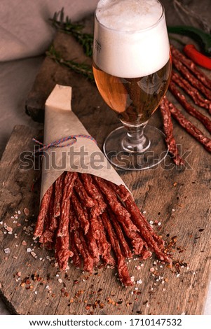 Dried pork and beef meat with bear on wooden background