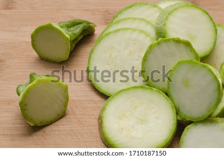 close-up of sliced zucchini on slices, on a light wooden board, home cooking