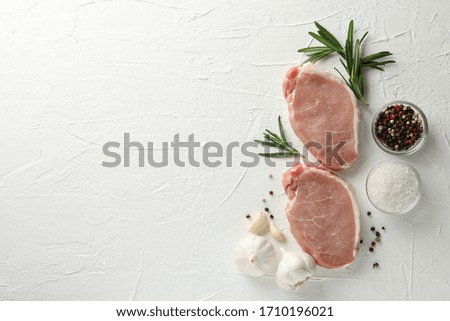 Composition with raw meat for steak and spices on white background