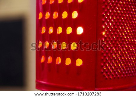 Red lamp from a kitchen grater. The decor of one of the cafes in the city of Pärnu.
