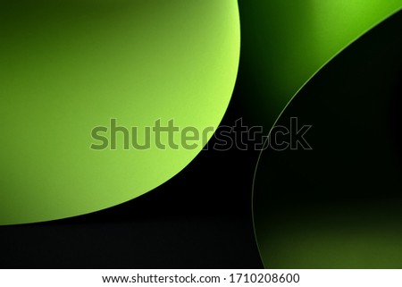Abstract - tree sheets of rolled green paper on black background. Simple, isolated object with copy space perfect for illustrating various concepts and ideas. Selective focus (shallow DOF).