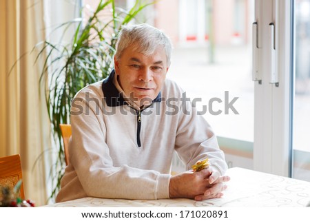 Portrait of senior man near window, indoor