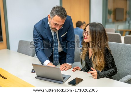 Two business people assess situation on computer screen