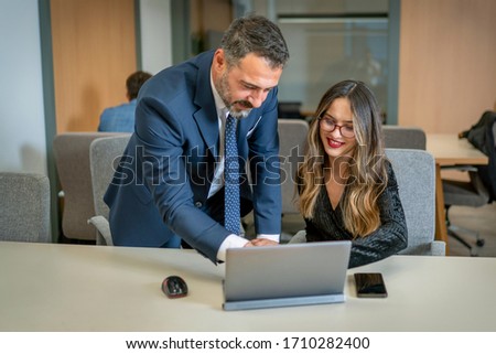 Two business people assess situation on computer screen