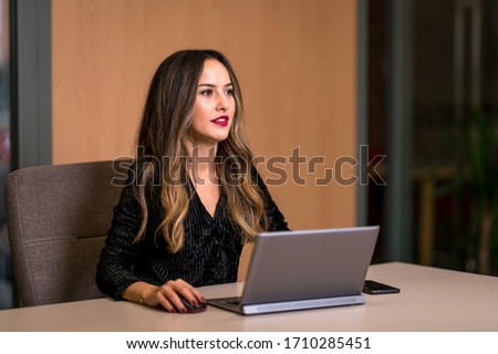 A woman trying to get her job done by computer in her office