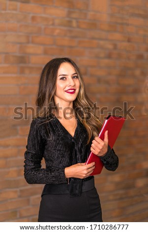 A beautiful woman ready for a team meeting with her red file.