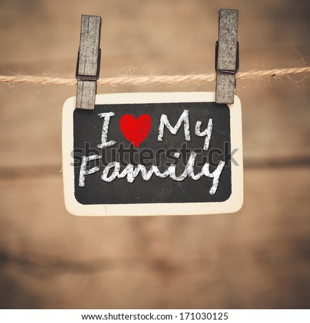  I love my family handwritten with white chalk on old photo and clothes peg on a wooden background