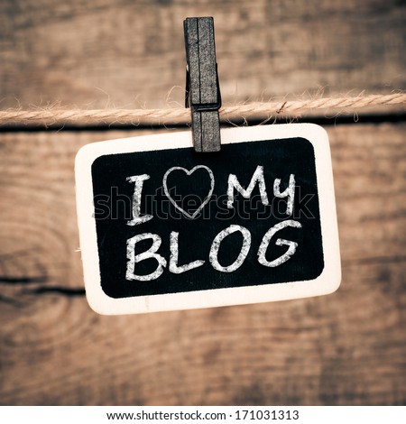 I love my blog handwritten with white chalk on old photo and clothes peg on a wooden background