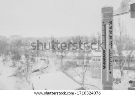 outdoor thermometer shows cool and cold temperature, black and white filter