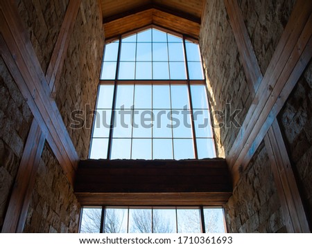 The picture of an old panoramic window in the castle. Huge window with wooden frame