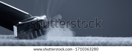 Home cleaning. Steam carpet cleaning on a grey background. Photo from copy space. Royalty-Free Stock Photo #1710363280