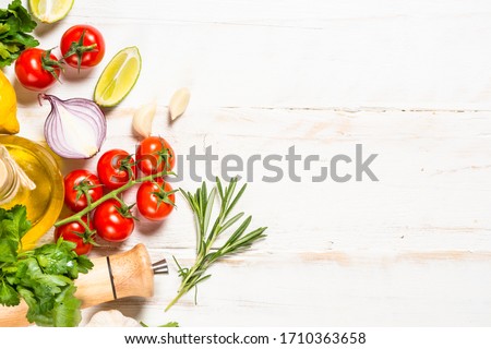 Food cooking background on white wooden table. Fresh vegetables, spices, herbs and oil. Ingredients for cooking with space for your text. Royalty-Free Stock Photo #1710363658