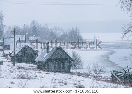 Old village during the snowfall. Empty beautiful Karelian village in winter. Village "Kolatselga"