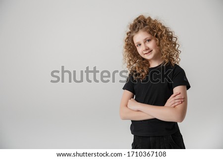 girl in a black t-shirt smiling on a white background, empty space