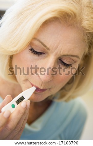 Woman Taking Her Temperature With Thermometer