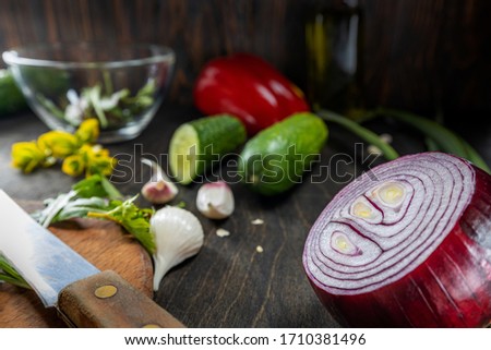 Fresh healthy vegetables for cooking vegan salad on a wooden table, the main object is red onion, the rest is blurry, shallow depth of field, selective focus. Organic food concept.
