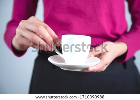 woman hand cup of coffee on grey background