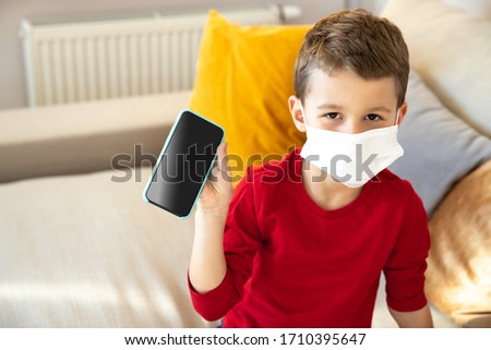 Top view portrait of little kid staying at home during isolation time and playing mobile games stock photo