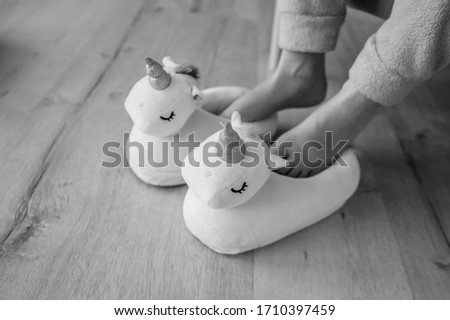 Pair of purple fluffy unicorn winter slippers against