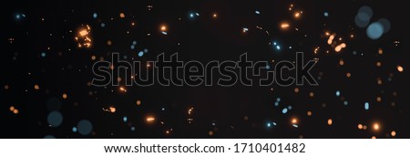 blurred yellow and cyan glow sparks from neon lights with blank spot on black backgound Royalty-Free Stock Photo #1710401482