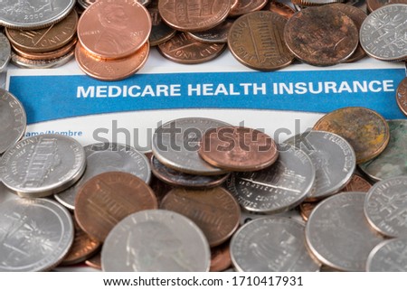 USA Medicare health insurance card with piles of loose change and cash to show funding crisis