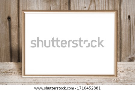 Gold photo frame on brown background of wood