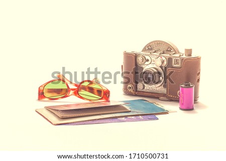 
Photograph of broken glasses, old camera with its case and plane tickets.