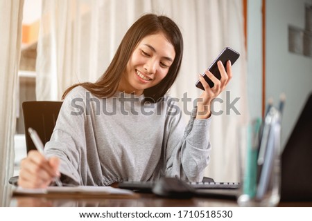 Woman work from home have a coffee cup beside wait epidemic situation to improve soon at home. Coronavirus, covid-19, Work from home (WFH), Social distancing, Quarantine, Prevent infection concept. Royalty-Free Stock Photo #1710518530