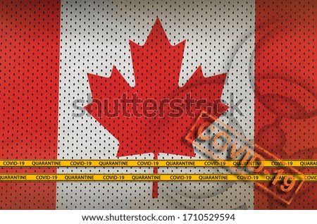 Canada flag and orange Covid-19 stamp with border tape. Coronavirus or 2019-nCov virus concept
